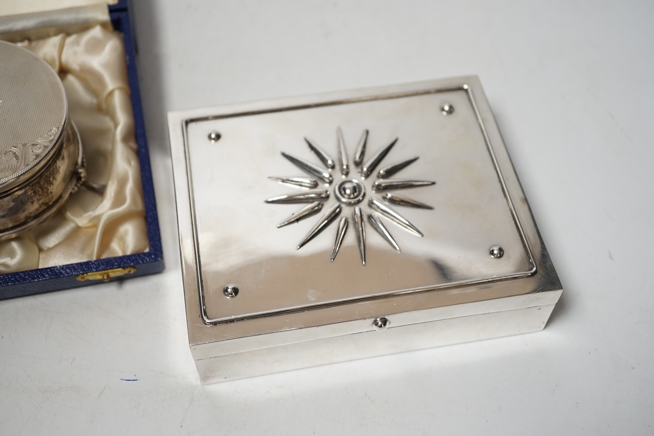 A modern engine turned silver trinket box, Birmingham, 1984, diameter, 82mm, together with a Greek 925 mounted cigarette box by Zolotas, 15cm.